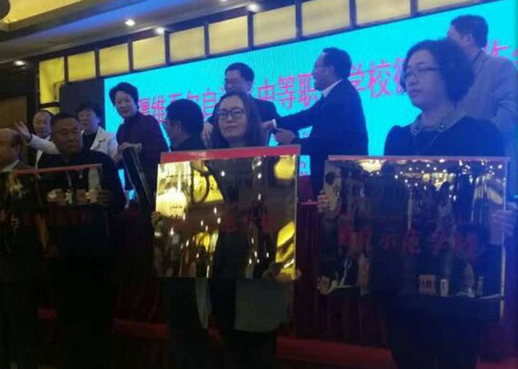 前排右二是思政处李红副处长代表学校领取自治区示范校奖状